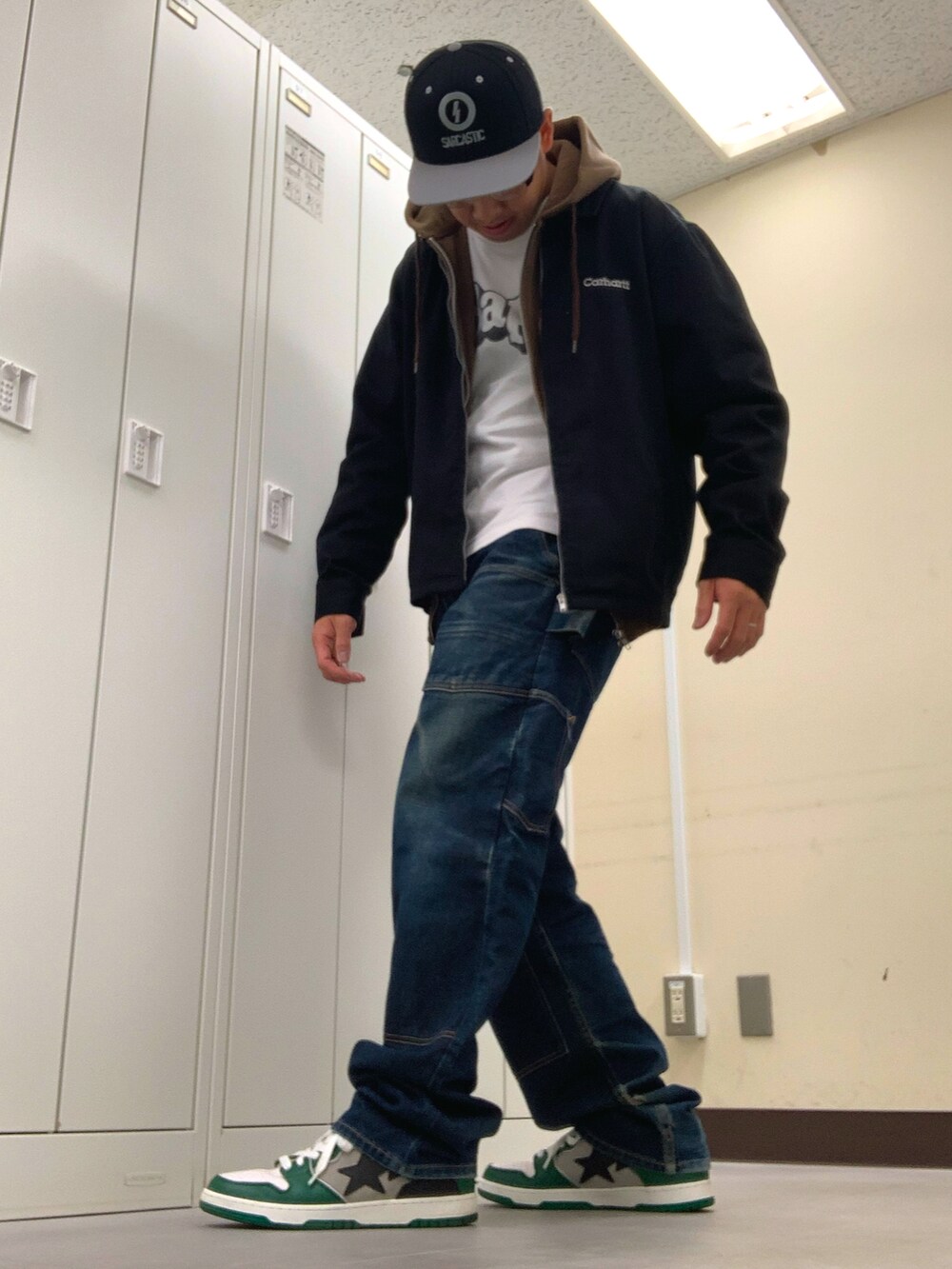 ホワイト系のTシャツ/カットソー、ブラック系のブルゾン、ブルー系のデニムパンツを着用したメンズの秋コーディネートの2枚目の写真