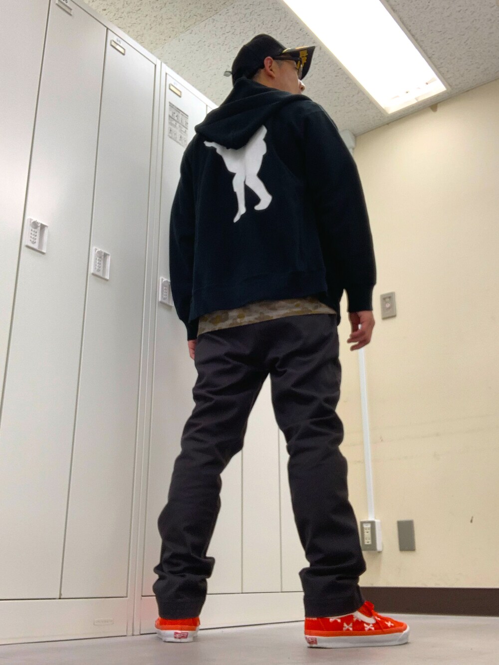 グリーン系のシャツ/ブラウス、ブラック系のパーカー、グレー系のチノパンツを着用したメンズの秋コーディネートの3枚目の写真