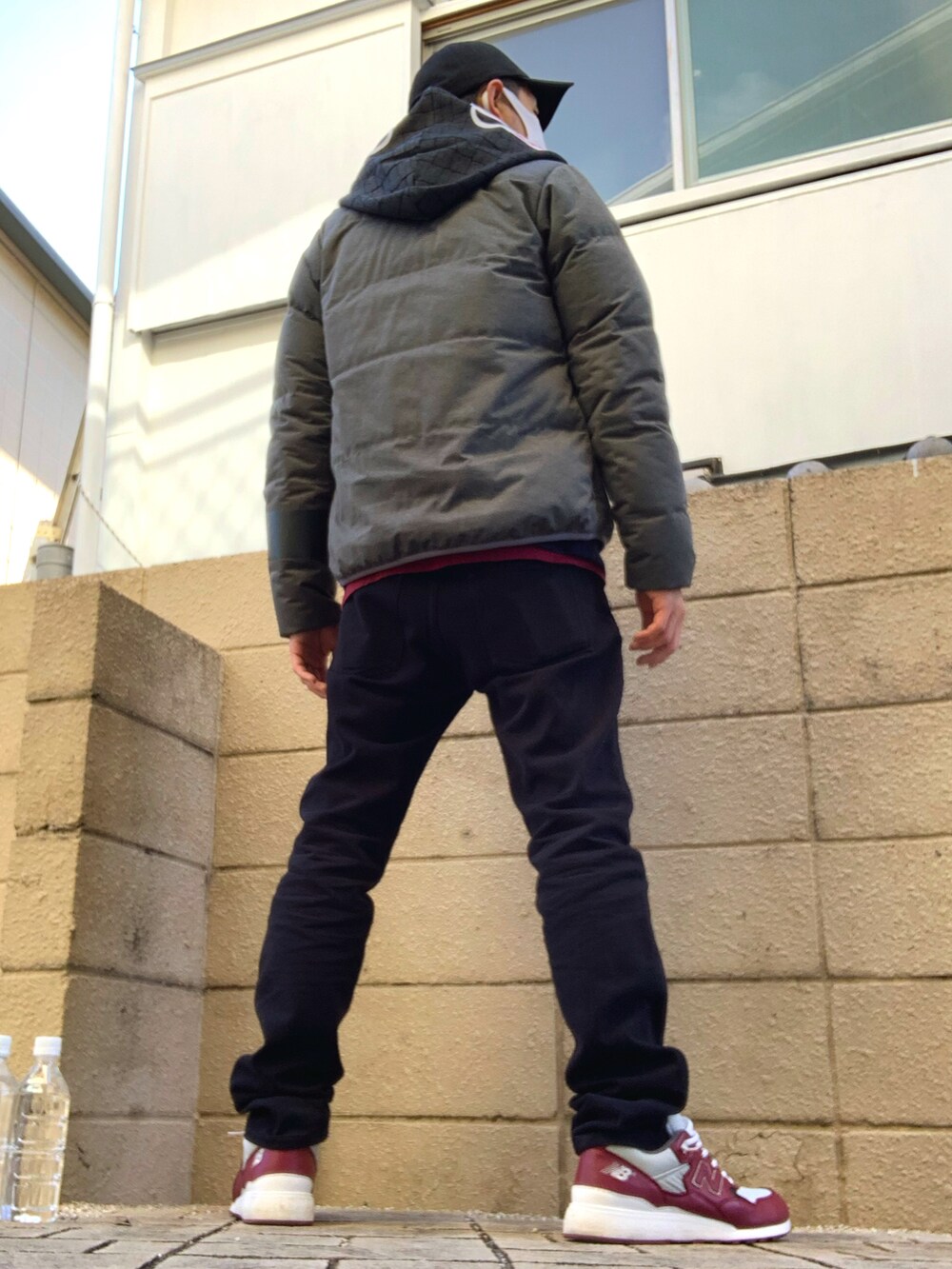 グレー系のダウンジャケット/コート、レッド系のTシャツ/カットソー、ブラック系のデニムパンツを着用したメンズの秋コーディネートの2枚目の写真