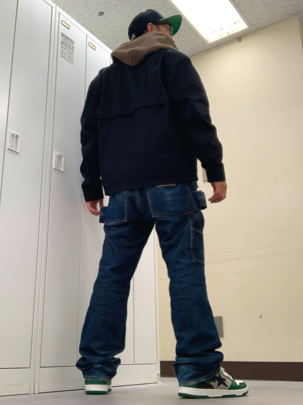 ホワイト系のTシャツ/カットソー、ブラック系のブルゾン、ブルー系のデニムパンツを着用したメンズの秋コーディネートの3枚目の写真