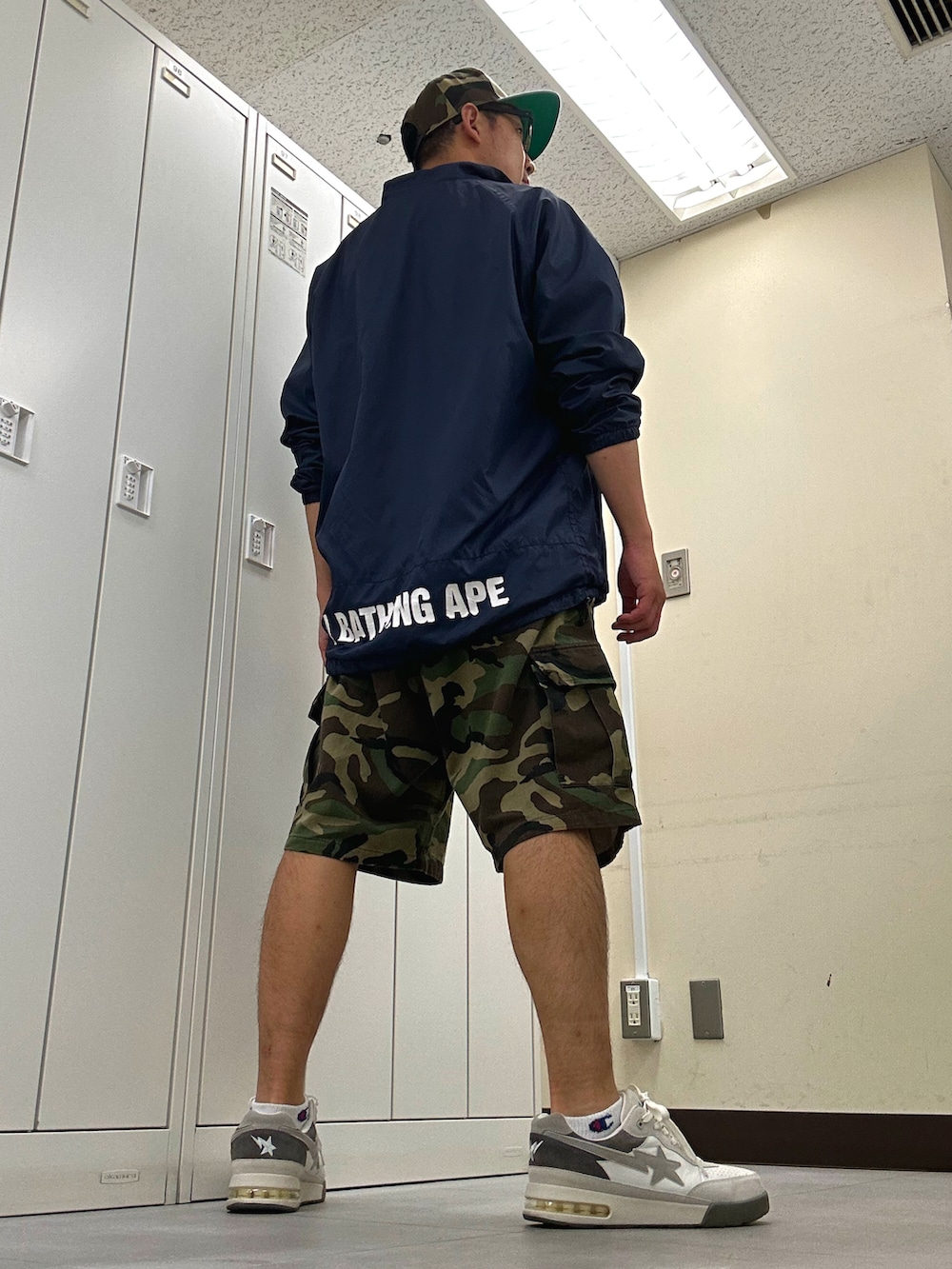 ホワイト系のTシャツ/カットソー、ブルー系のナイロンジャケット、グリーン系のカーゴパンツを着用したメンズの夏コーディネートの3枚目の写真