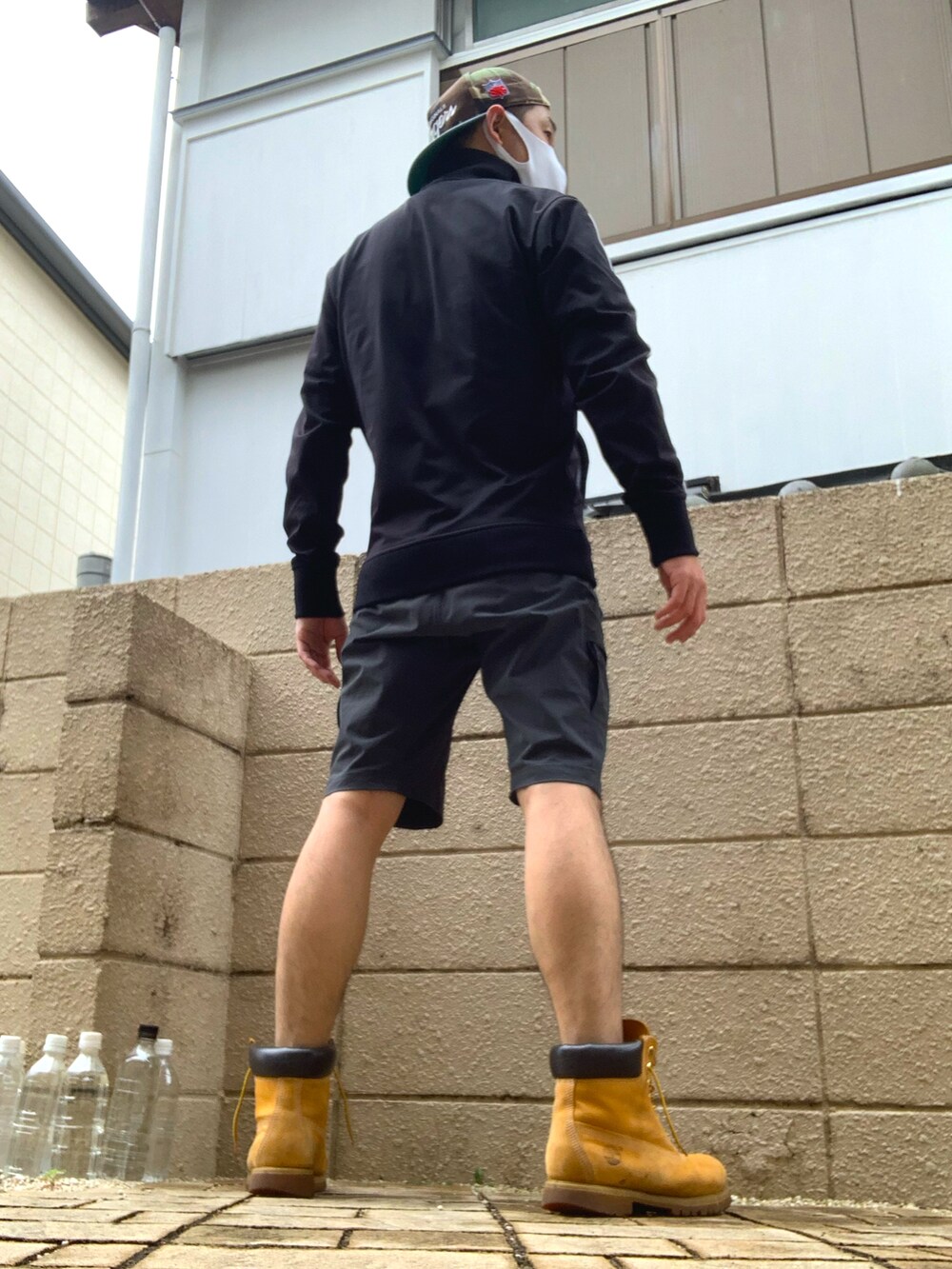 ブラック系のジャージ、グレー系のパンツ、イエロー系のブーツを着用したメンズの夏コーディネートの2枚目の写真