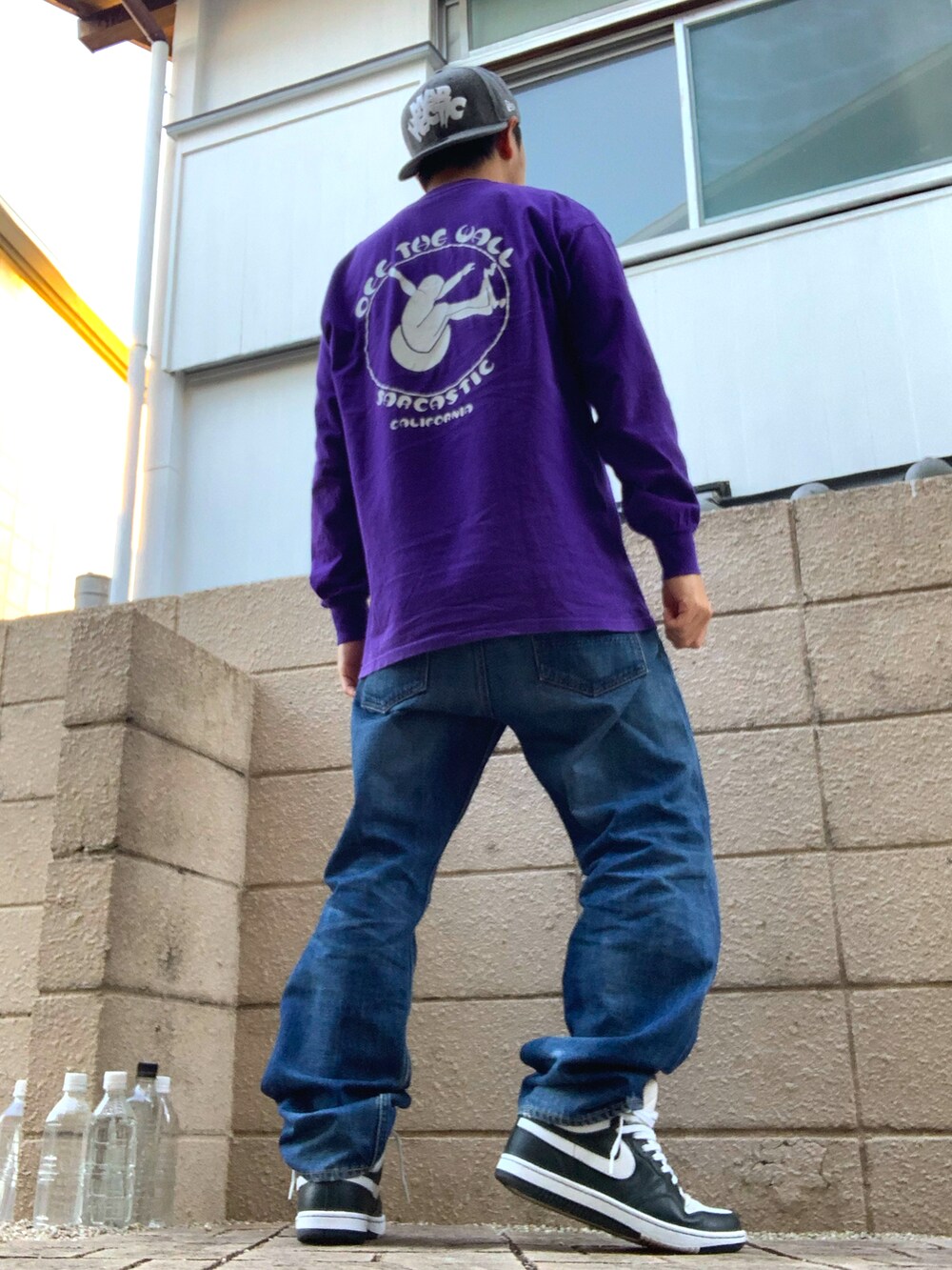 パープル系のTシャツ/カットソー、ブルー系のデニムパンツ、グリーン系のスニーカーを着用したメンズの秋コーディネートの2枚目の写真