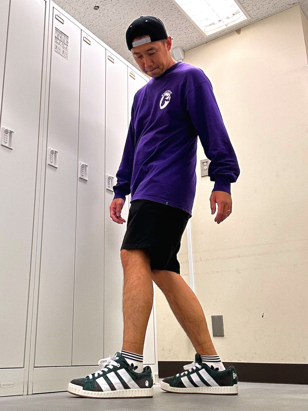 パープル系のTシャツ/カットソー、ブラック系のチノパンツ、グリーン系のスニーカーを着用したメンズの秋コーディネートの2枚目の写真