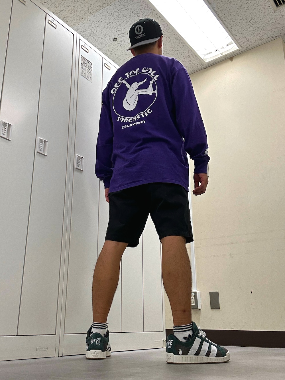 パープル系のTシャツ/カットソー、ブラック系のチノパンツ、グリーン系のスニーカーを着用したメンズの秋コーディネートの3枚目の写真