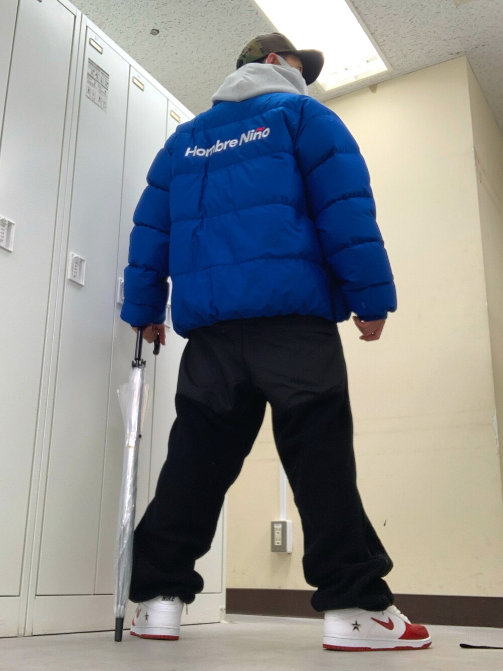 ブルー系のダウンジャケット/コート、ブラック系のベスト、ブラック系のその他パンツを着用したメンズの春コーディネートの2枚目の写真