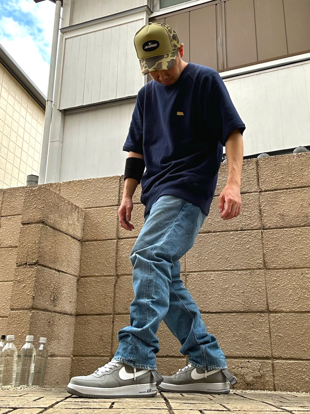 ブルー系のスウェット、ブルー系のデニムパンツ、グレー系のスニーカーを着用したメンズの春コーディネートの2枚目の写真