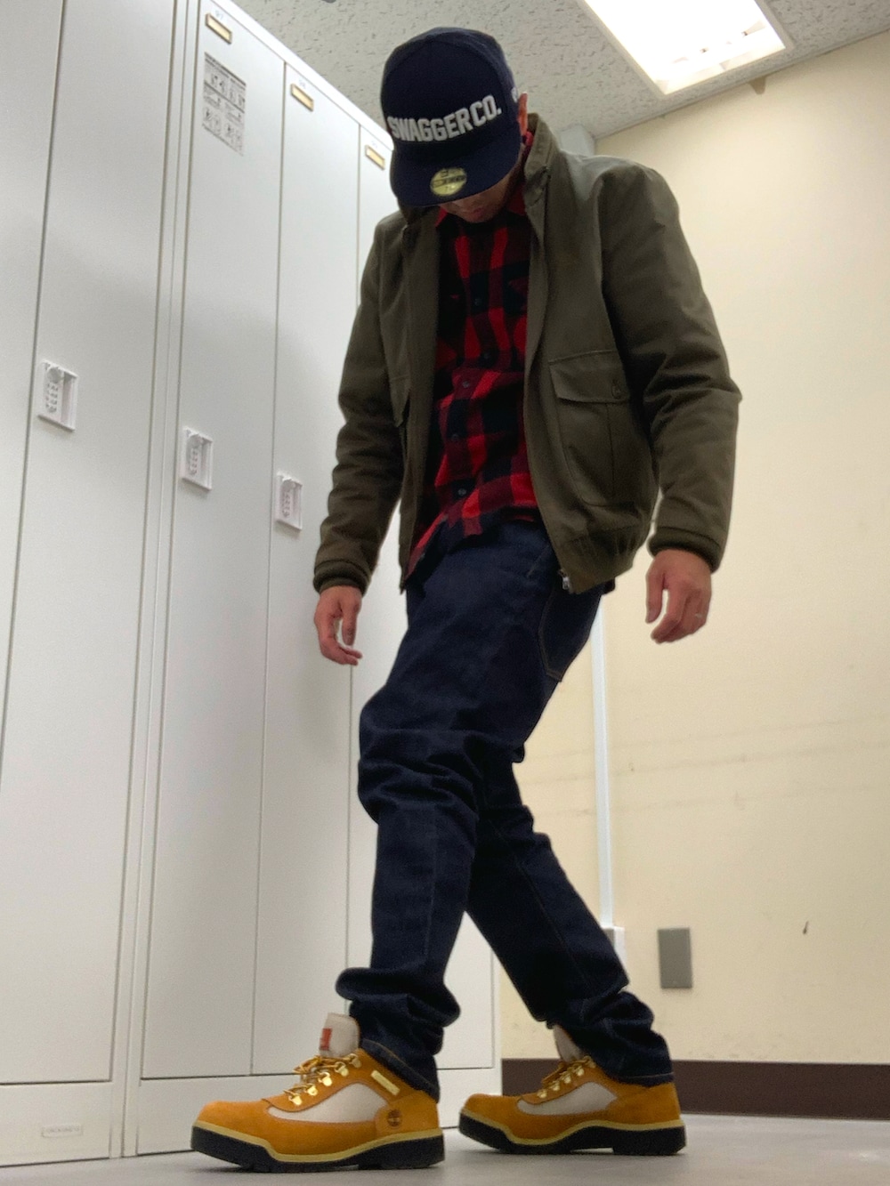 レッド系のシャツ/ブラウス、グリーン系のミリタリージャケット、ブルー系のデニムパンツを着用したメンズの冬コーディネートの2枚目の写真