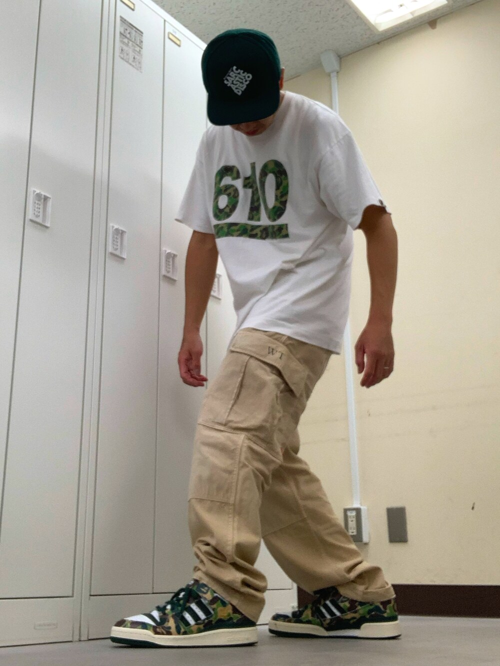 ホワイト系のTシャツ/カットソー、ベージュ系のカーゴパンツ、グリーン系のスニーカーを着用したメンズの秋コーディネートの2枚目の写真