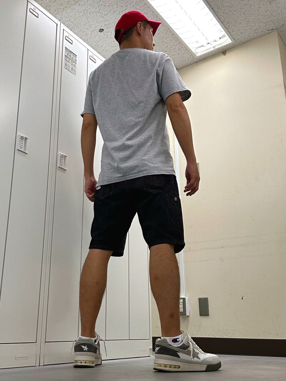 グレー系のTシャツ/カットソー、ブラック系のデニムパンツ、ホワイト系のスニーカーを着用したメンズの秋コーディネートの2枚目の写真