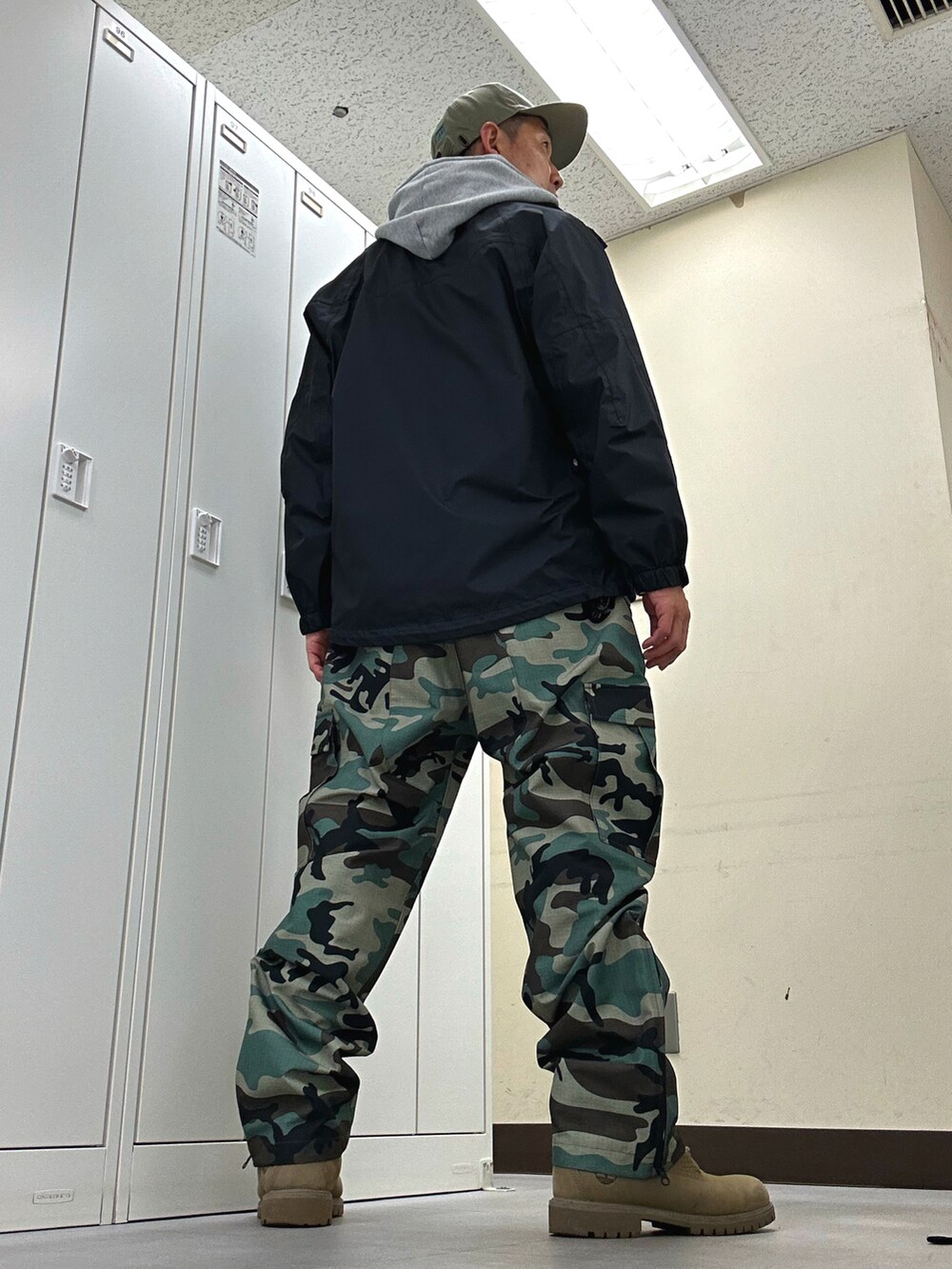 ブラック系のナイロンジャケット、グリーン系のTシャツ/カットソー、グリーン系のカーゴパンツを着用したメンズの春コーディネートの3枚目の写真