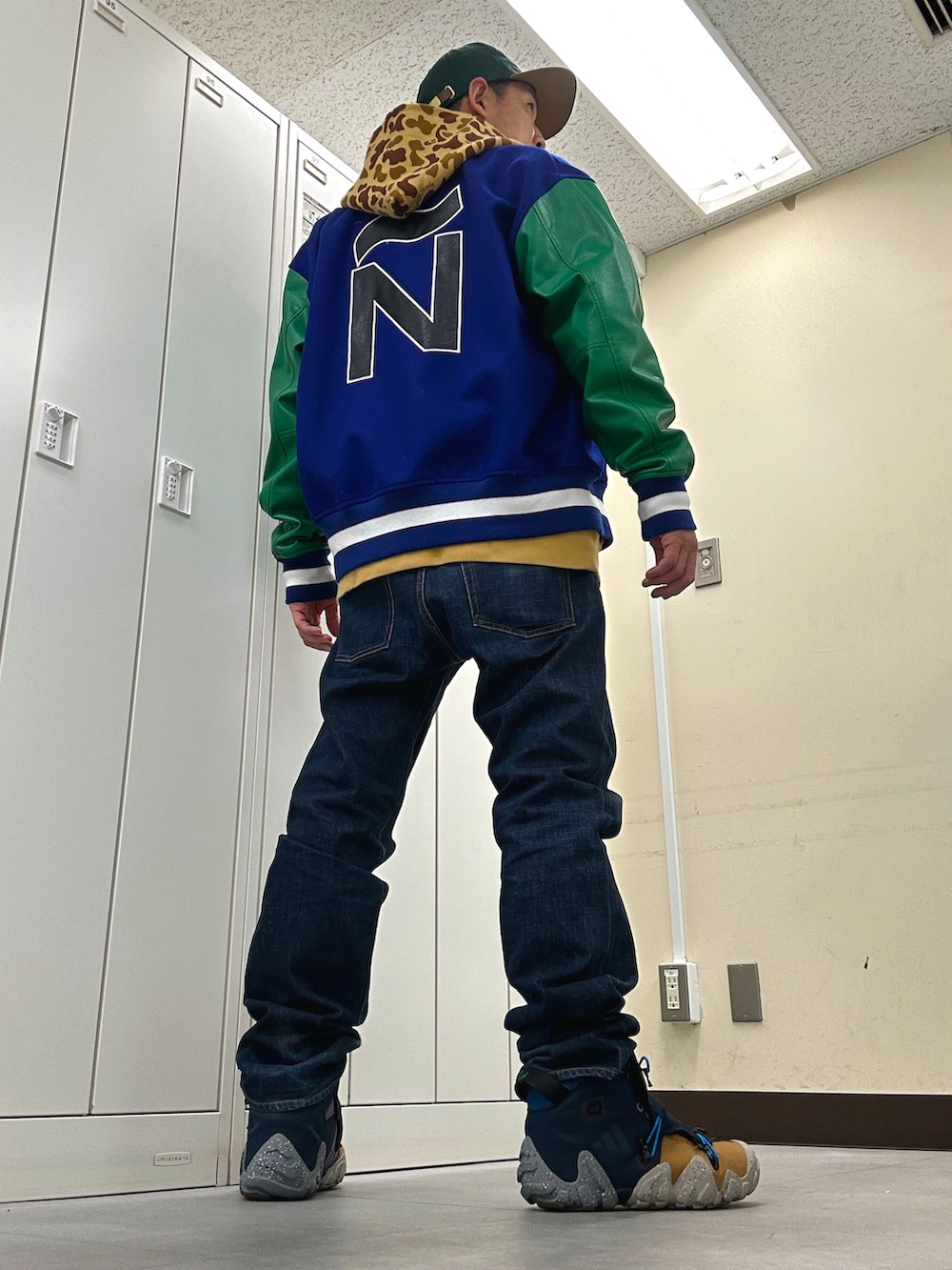 ブルー系のスタジャン、ブルー系のデニムパンツ、ブルー系のスニーカーを着用したメンズの冬コーディネートの3枚目の写真