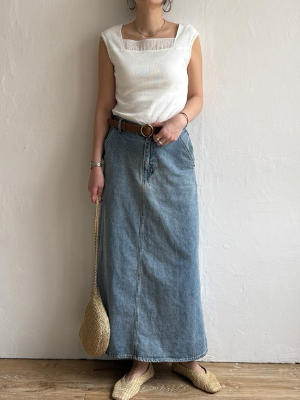 ブラウン系のタンクトップ、ブルー系のスカート、ゴールド系のショルダーバッグを着用したレディースの春コーディネートの2枚目の写真