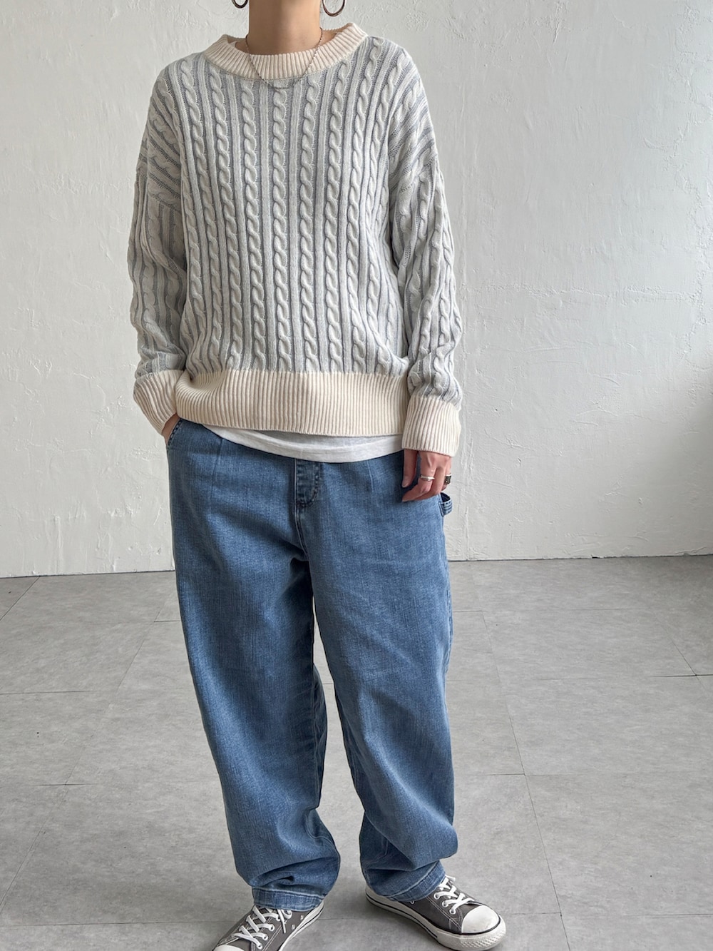 グリーン系のニット/セーター、ブルー系のデニムパンツ、グレー系のスニーカーを着用したレディースの冬コーディネートの4枚目の写真