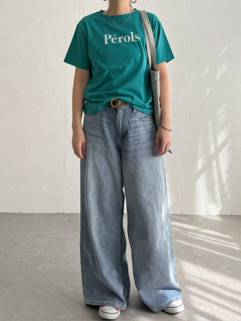 ピンク系のTシャツ/カットソー、ブルー系のパンツ、ホワイト系のスニーカーを着用したレディースの春コーディネートの4枚目の写真