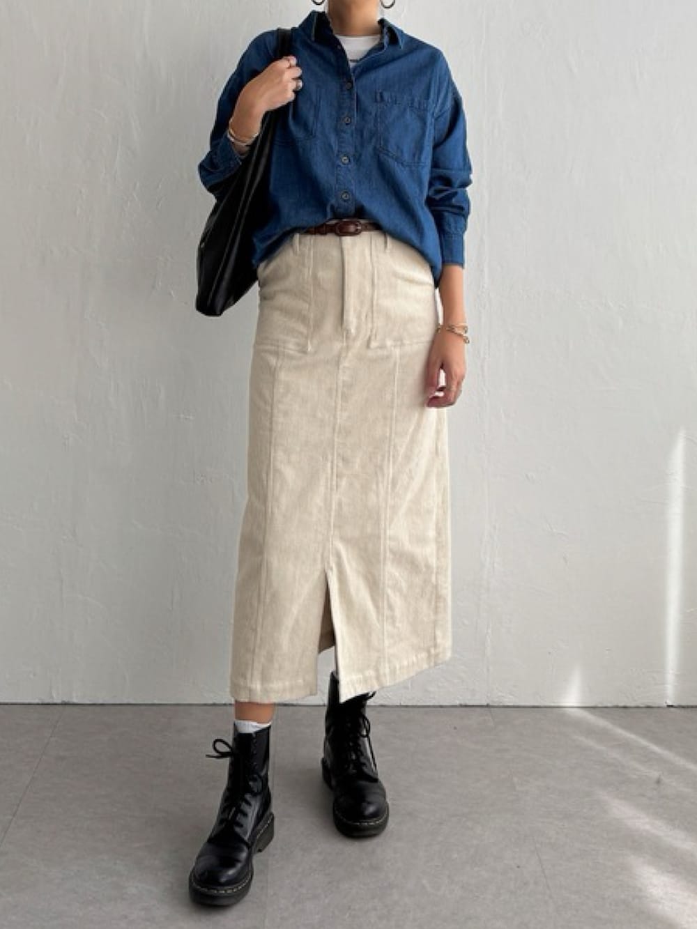 グレー系のスカート、ブルー系のシャツ/ブラウス、ブラック系のブーツを着用したレディースの秋コーディネートの3枚目の写真