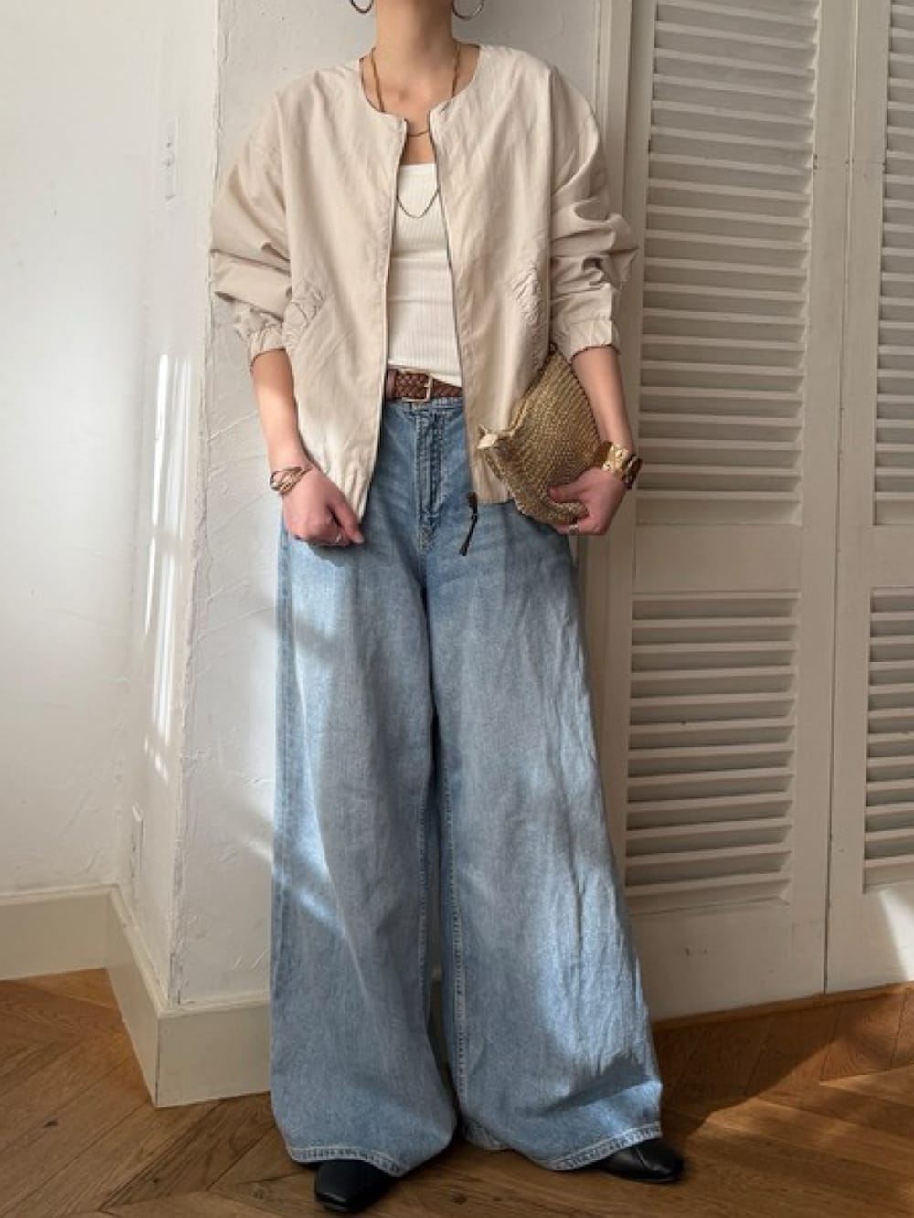 グリーン系のブルゾン、ブルー系のデニムパンツ、ホワイト系のトップスを着用したレディースの冬コーディネートの4枚目の写真