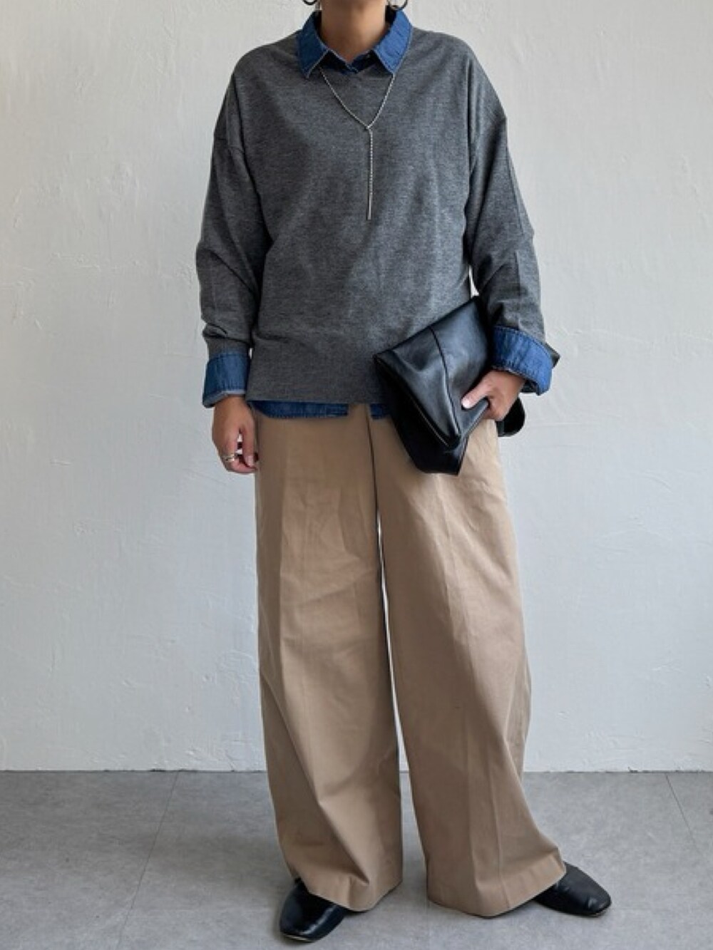 ベージュ系のパンツ、レッド系のニット/セーター、ブルー系のシャツ/ブラウスを着用したレディースの秋コーディネートの2枚目の写真