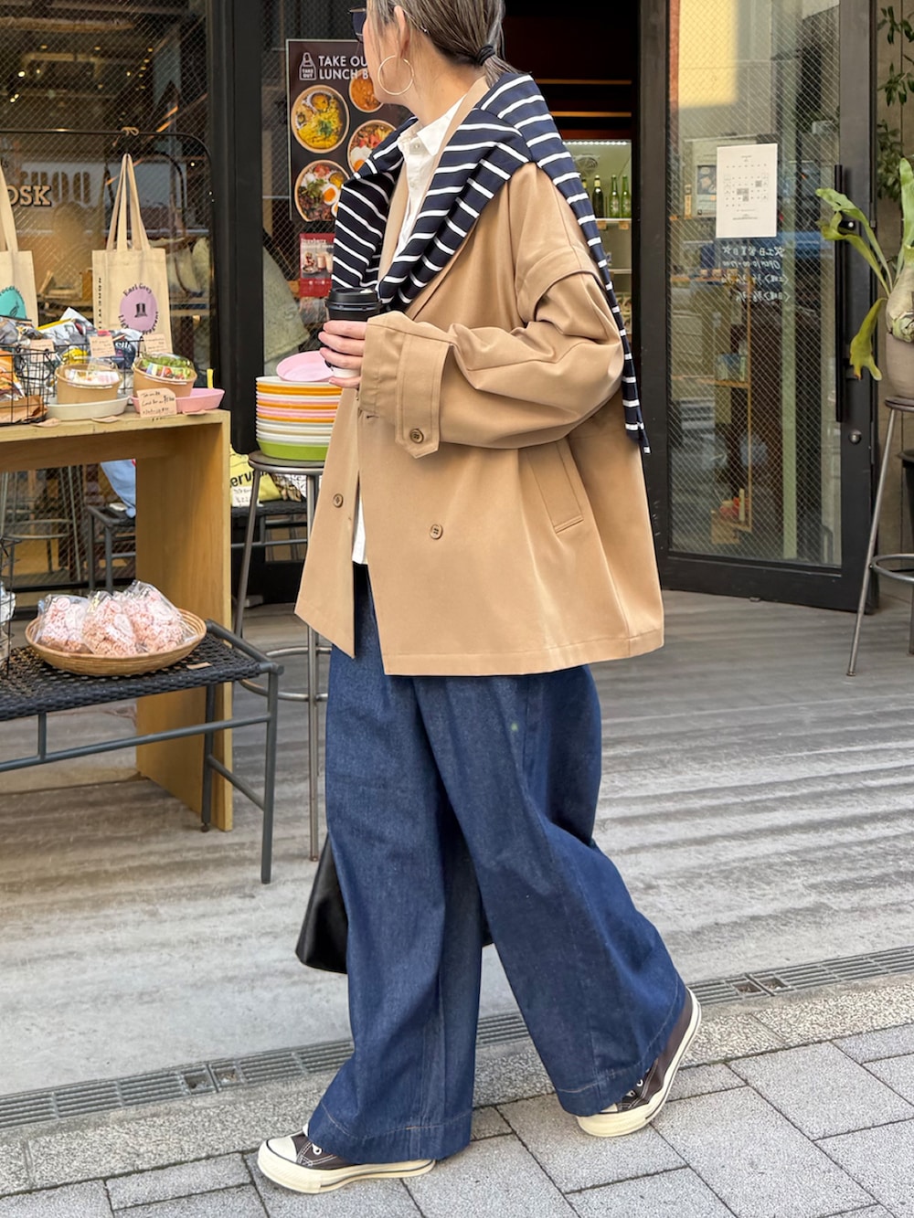 ベージュ系のピーコート、ブルー系のその他パンツ、グレー系のスニーカーを着用したレディースの春コーディネートの3枚目の写真