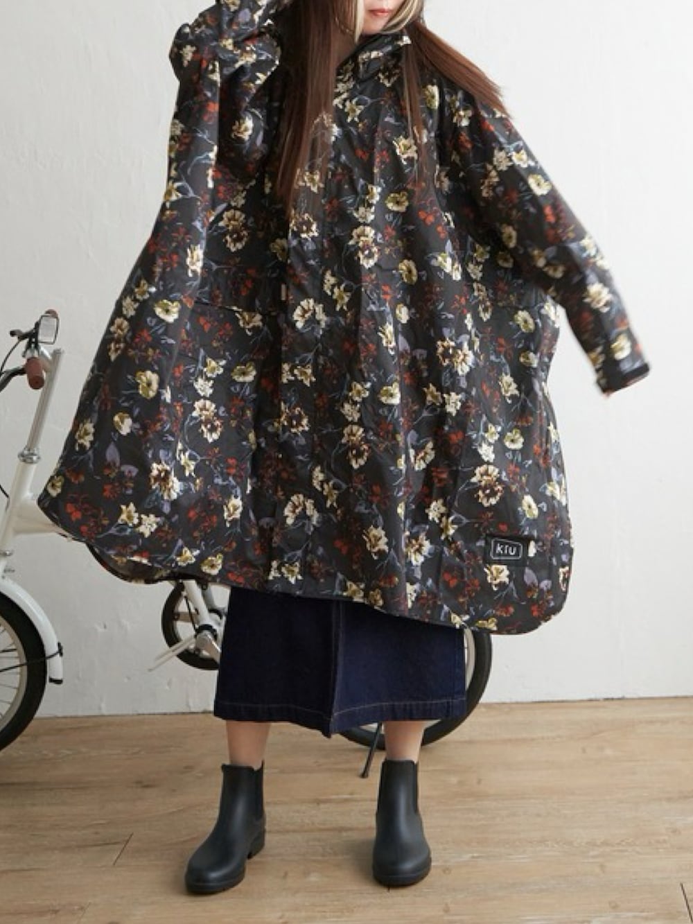 グレー系のレインコート/ポンチョを着用したレディースの春コーディネートの2枚目の写真