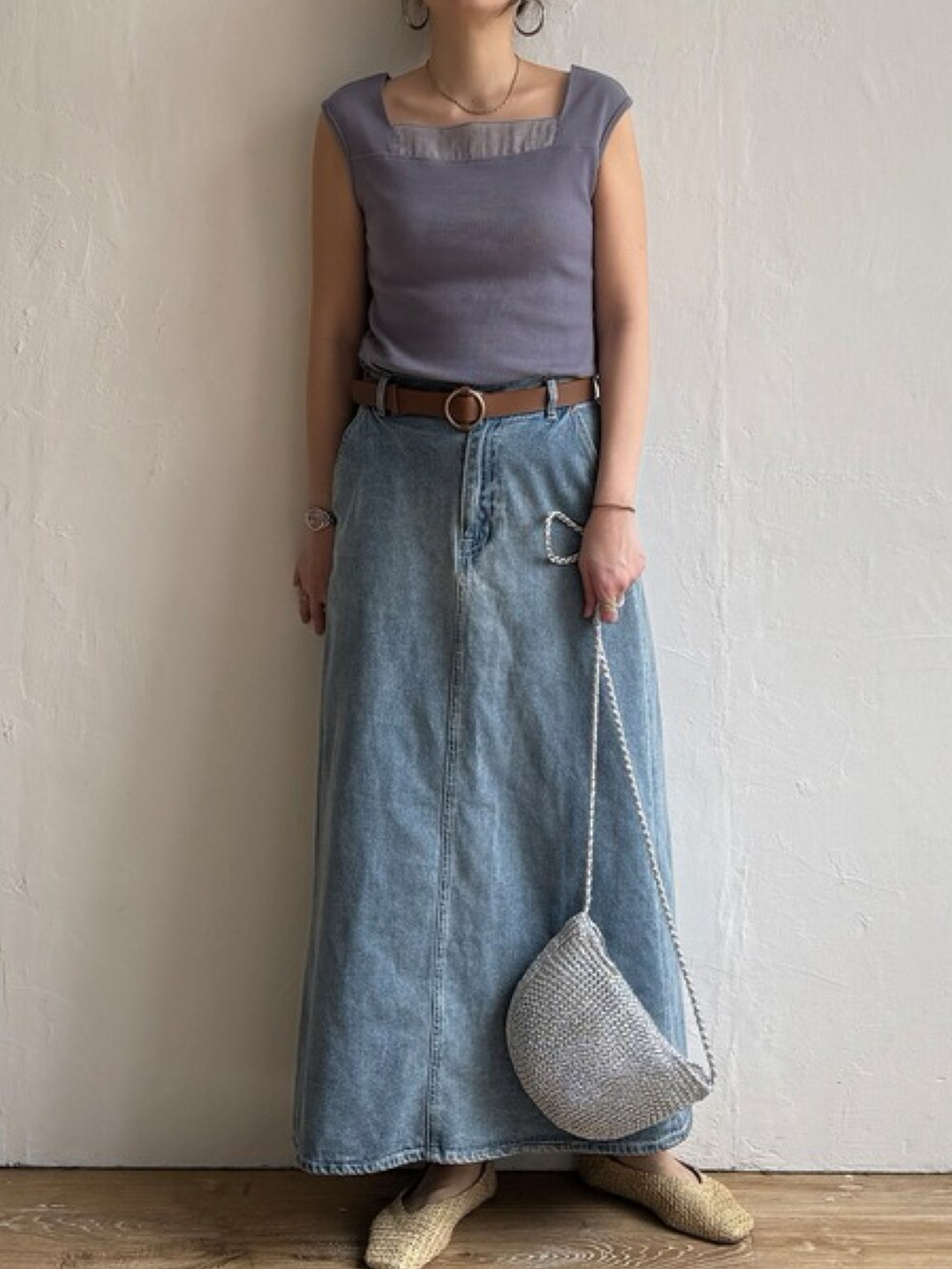 ブラウン系のタンクトップ、ブルー系のスカート、ゴールド系のショルダーバッグを着用したレディースの春コーディネートの3枚目の写真