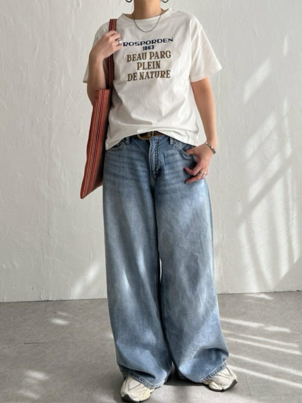 ピンク系のTシャツ/カットソー、ブルー系のパンツ、ホワイト系のスニーカーを着用したレディースの春コーディネートの2枚目の写真