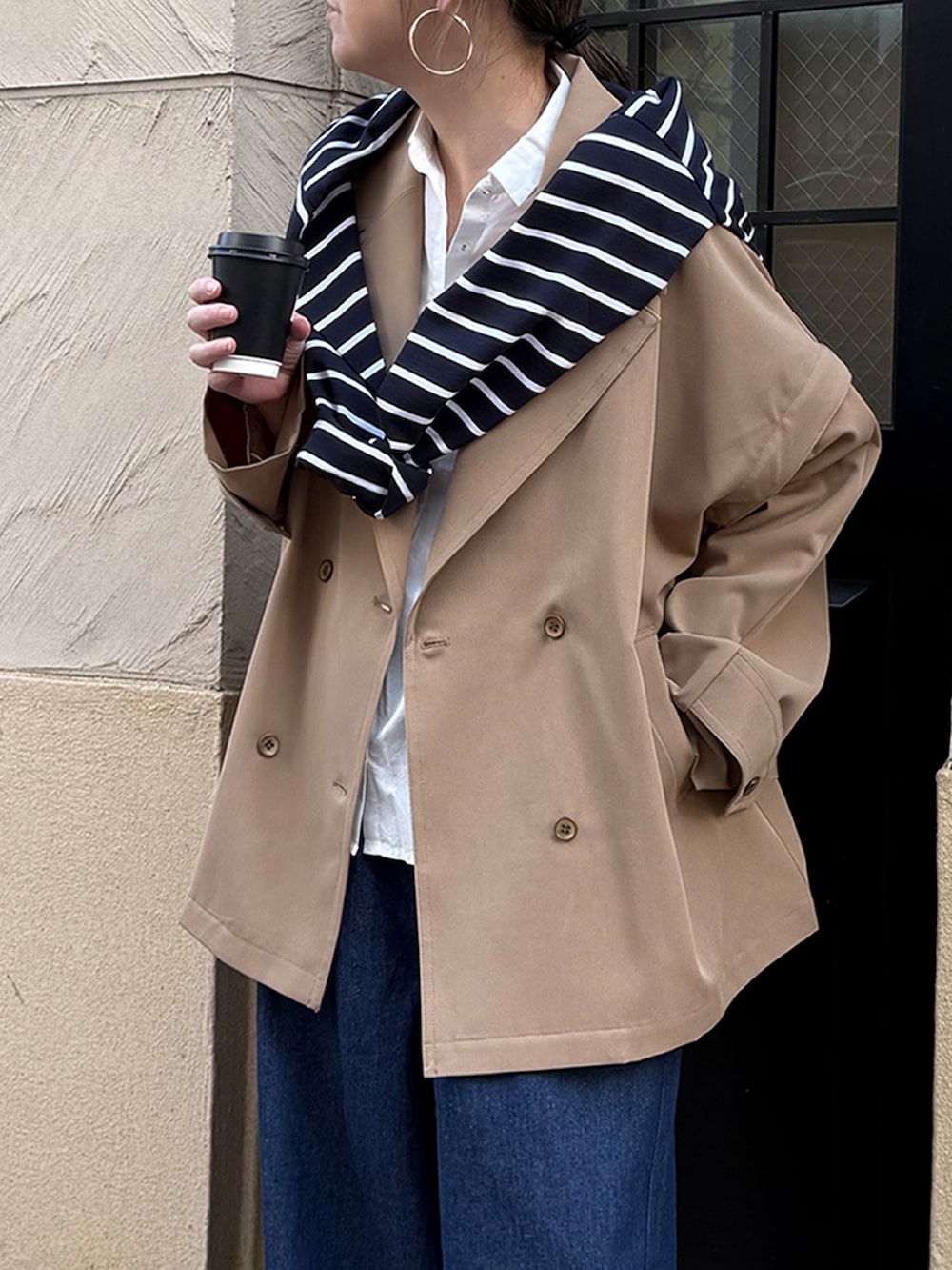 ベージュ系のピーコート、ブルー系のその他パンツ、グレー系のスニーカーを着用したレディースの春コーディネートの2枚目の写真