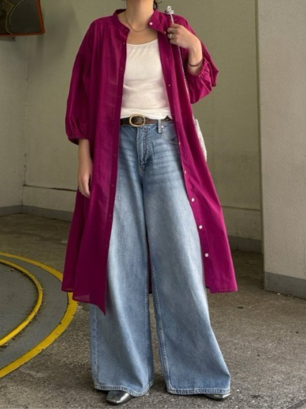 グリーン系のワンピース、ゴールド系のショルダーバッグ、ブルー系のデニムパンツを着用したレディースの春コーディネートの2枚目の写真