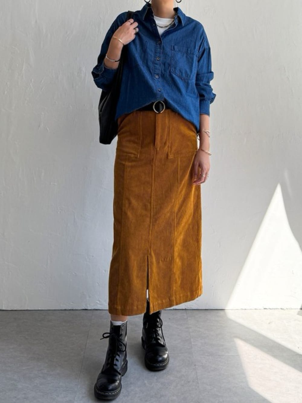 グレー系のスカート、ブルー系のシャツ/ブラウス、ブラック系のブーツを着用したレディースの秋コーディネートの2枚目の写真