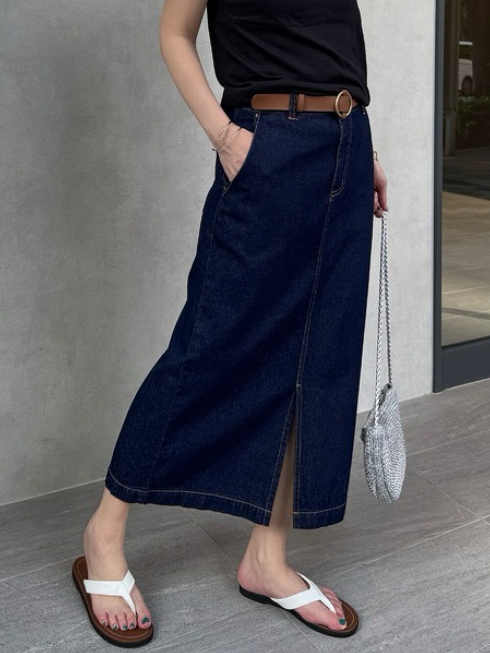 ブルー系のスカート、ブラック系のトップスを着用したレディースの夏コーディネートの2枚目の写真