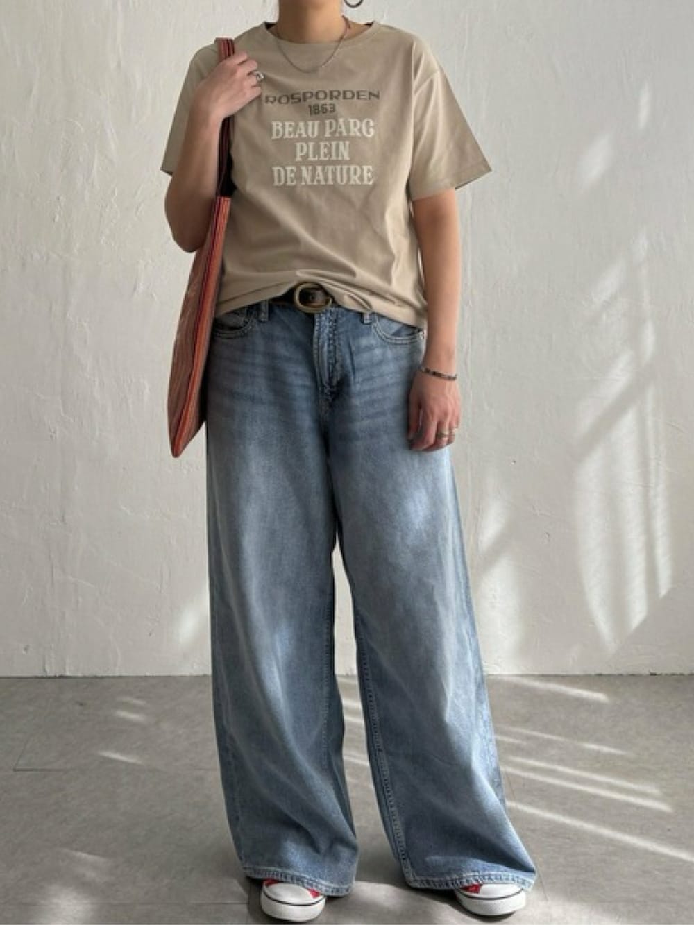 ピンク系のTシャツ/カットソー、ブルー系のパンツ、ホワイト系のスニーカーを着用したレディースの春コーディネートの3枚目の写真