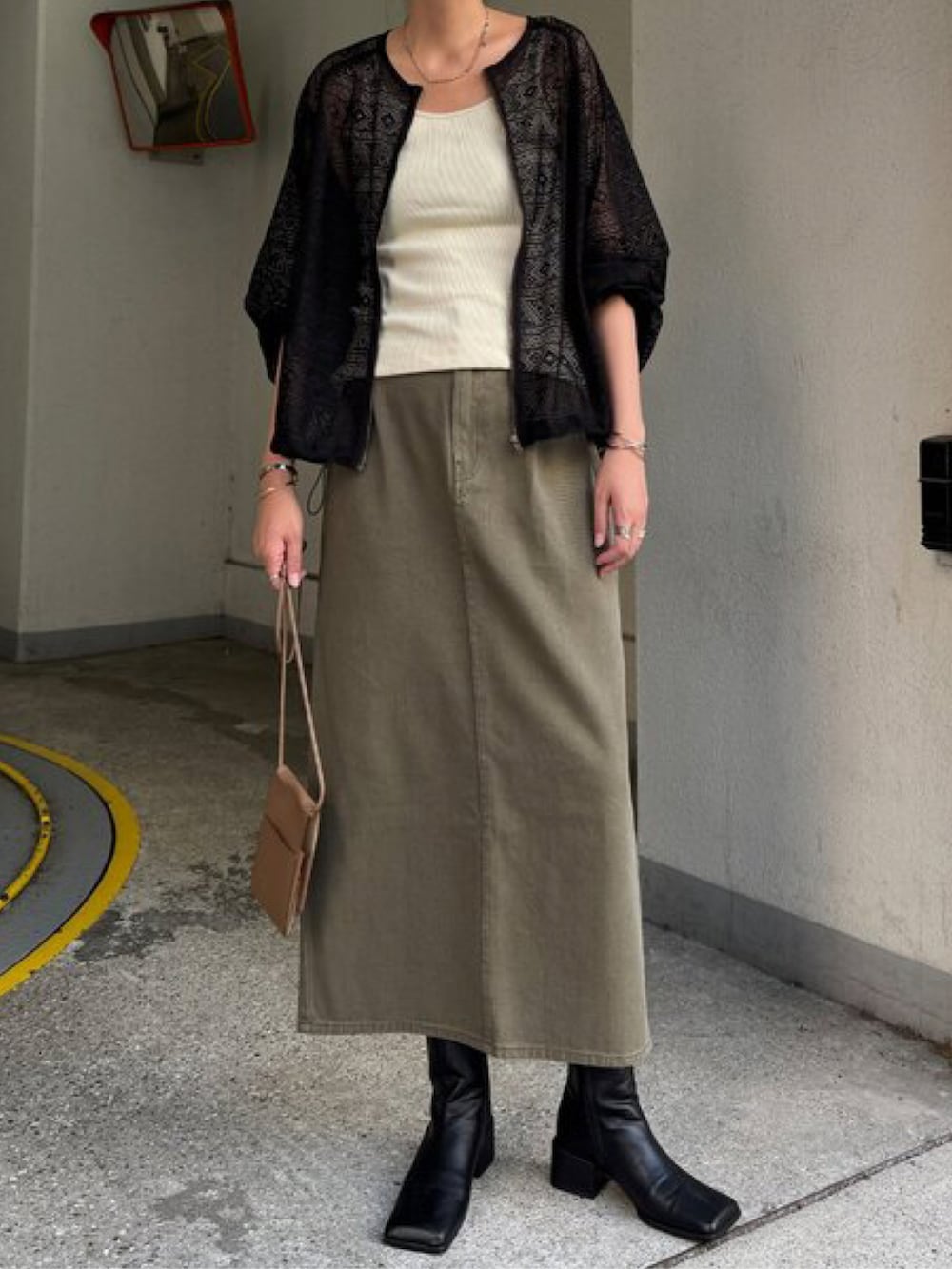 ブラック系のブルゾン、グリーン系のスカートを着用したレディースの夏コーディネートの4枚目の写真