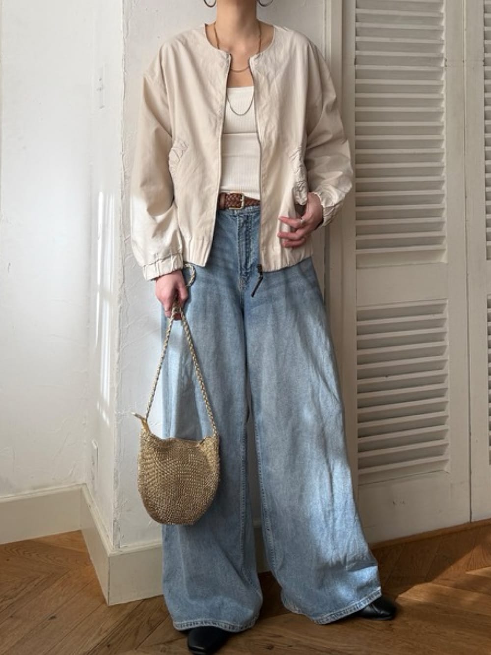 グリーン系のブルゾン、ブルー系のデニムパンツ、ホワイト系のトップスを着用したレディースの冬コーディネートの3枚目の写真