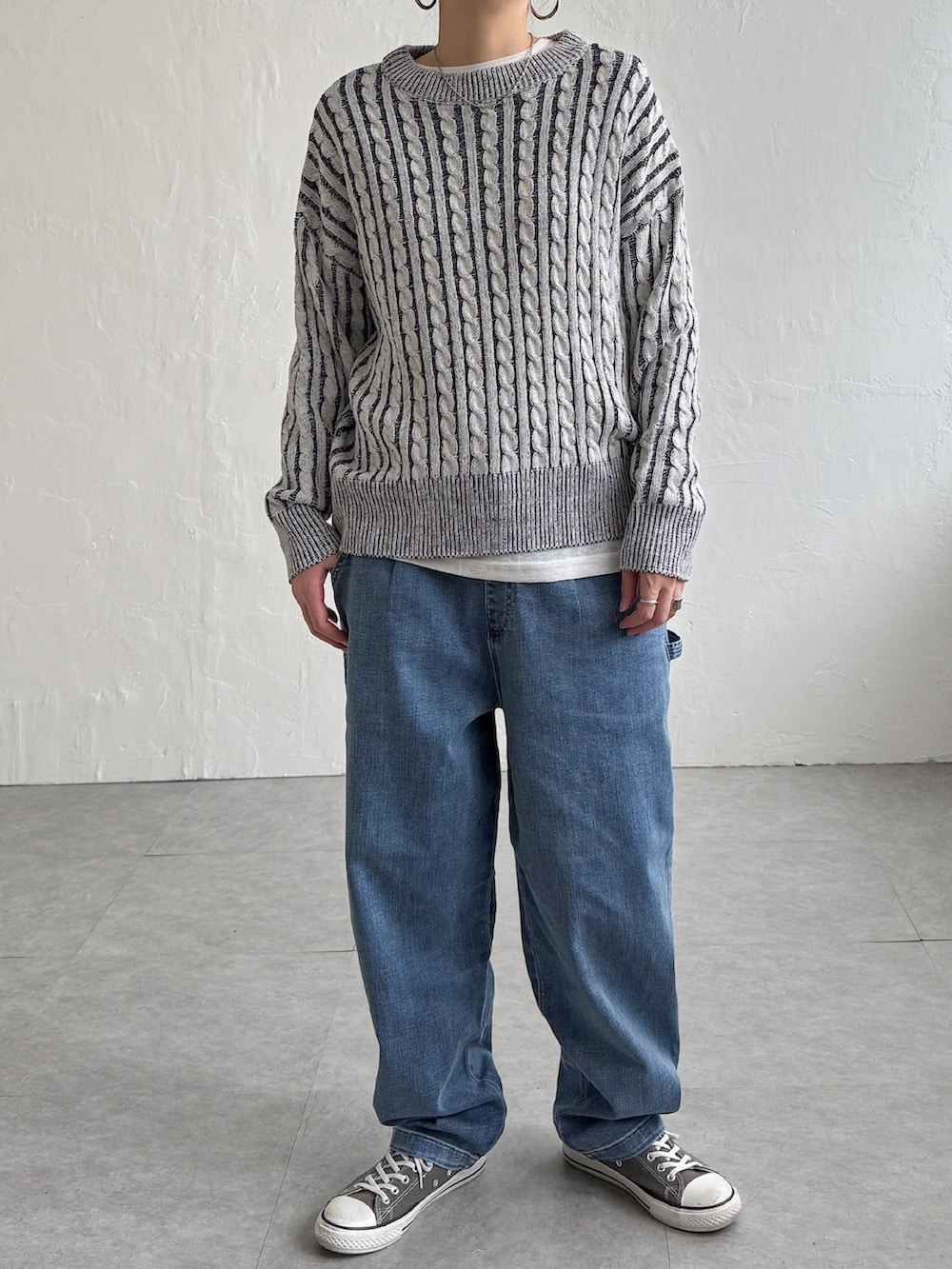 グリーン系のニット/セーター、ブルー系のデニムパンツ、グレー系のスニーカーを着用したレディースの冬コーディネートの3枚目の写真