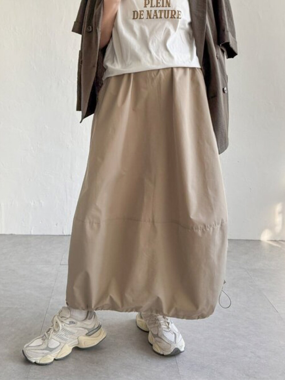 ベージュ系のスカート、その他のTシャツ/カットソー、グリーン系のテーラードジャケットを着用したレディースの春コーディネートの2枚目の写真