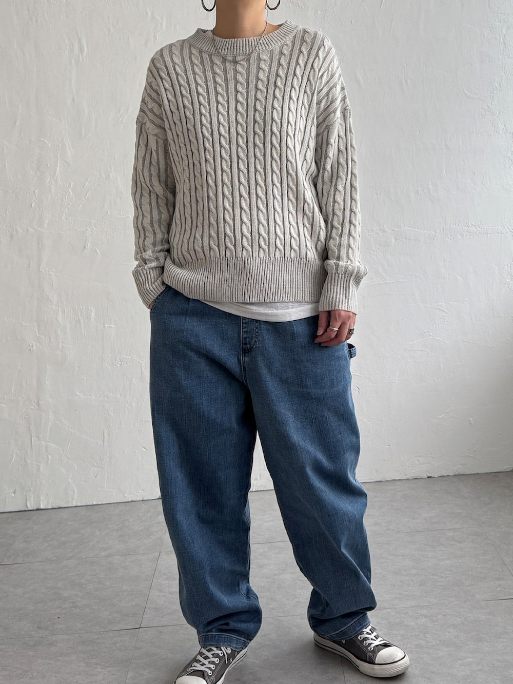 グリーン系のニット/セーター、ブルー系のデニムパンツ、グレー系のスニーカーを着用したレディースの冬コーディネートの2枚目の写真