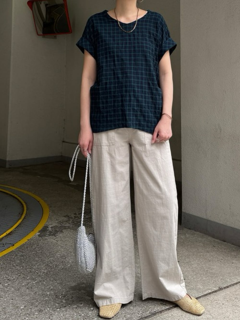 ホワイト系のシャツ/ブラウス、ベージュ系のトートバッグ、ブルー系のパンツを着用したレディースの夏コーディネートの4枚目の写真