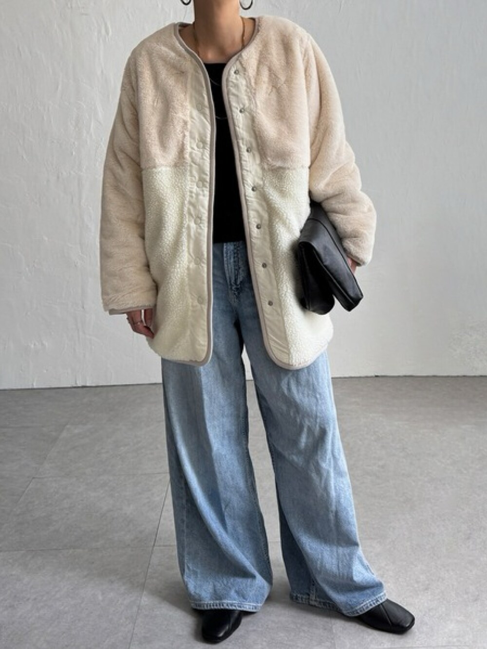 ベージュ系のブルゾン、ブルー系のパンツ、ホワイト系のトップスを着用したレディースの秋コーディネートの2枚目の写真