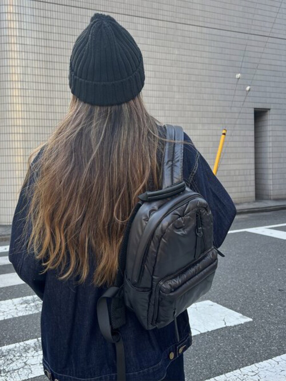 ブラック系のショルダーバッグ、ブルー系のデニムパンツ、ブルー系のデニムジャケットを着用したレディースの秋コーディネートの2枚目の写真