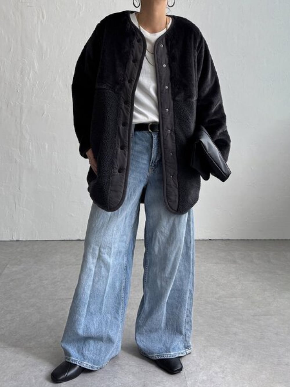 ベージュ系のブルゾン、ブルー系のパンツ、ホワイト系のトップスを着用したレディースの秋コーディネートの3枚目の写真