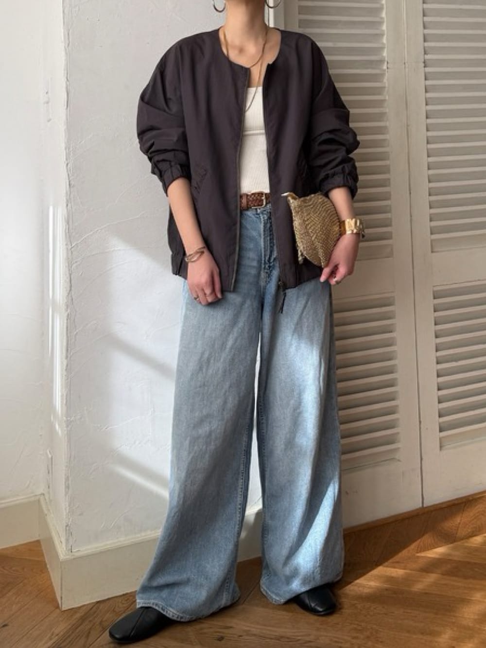 グリーン系のブルゾン、ブルー系のデニムパンツ、ホワイト系のトップスを着用したレディースの冬コーディネートの5枚目の写真