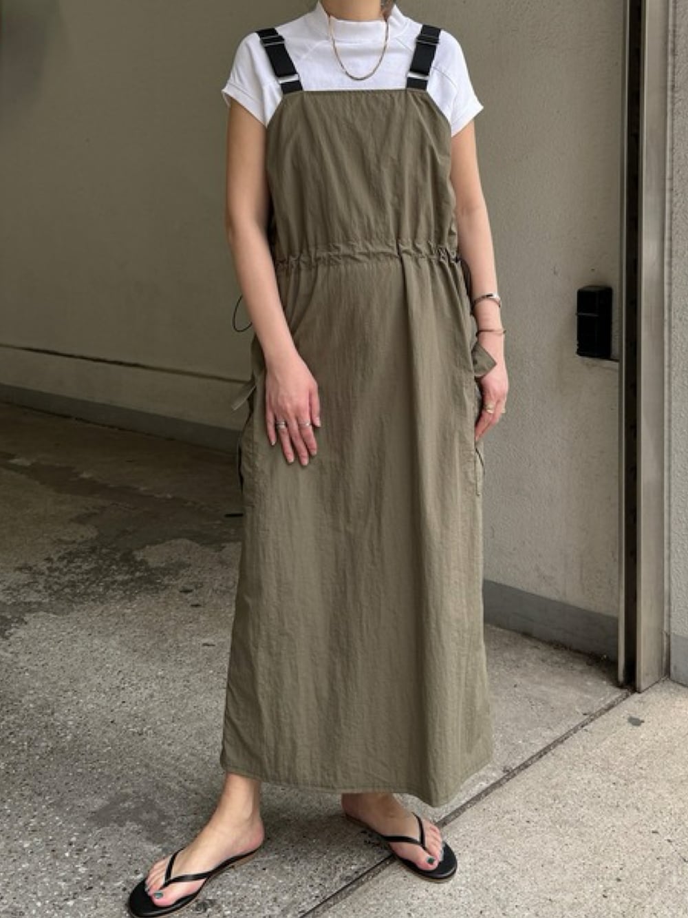 ブラック系のワンピース、グレー系のショルダーバッグ、ホワイト系のトップスを着用したレディースの春コーディネートの2枚目の写真