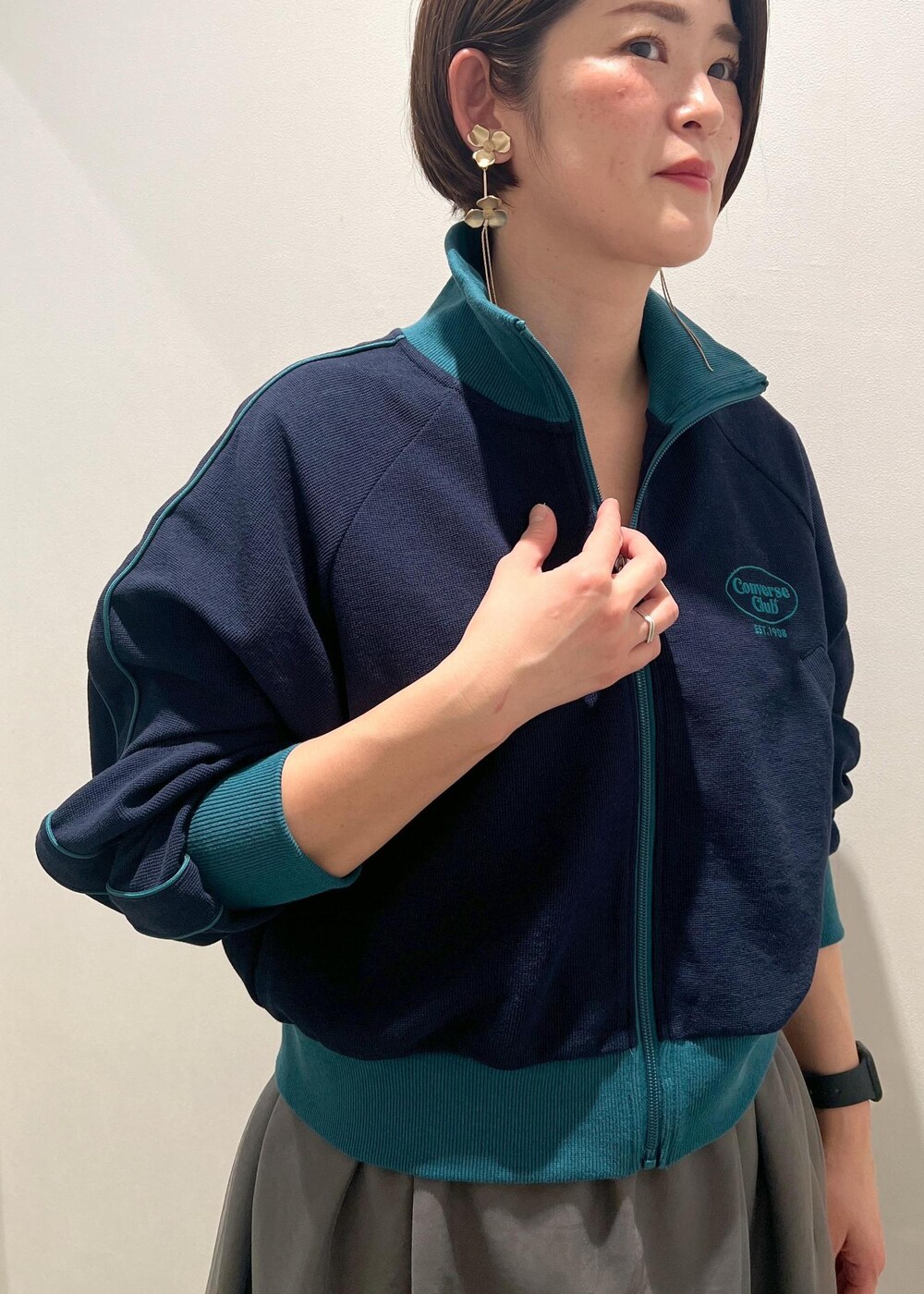 シルバー系のハンドバッグ、シルバー系のその他シューズ、グレー系のスカートを着用したレディースの春コーディネートの4枚目の写真
