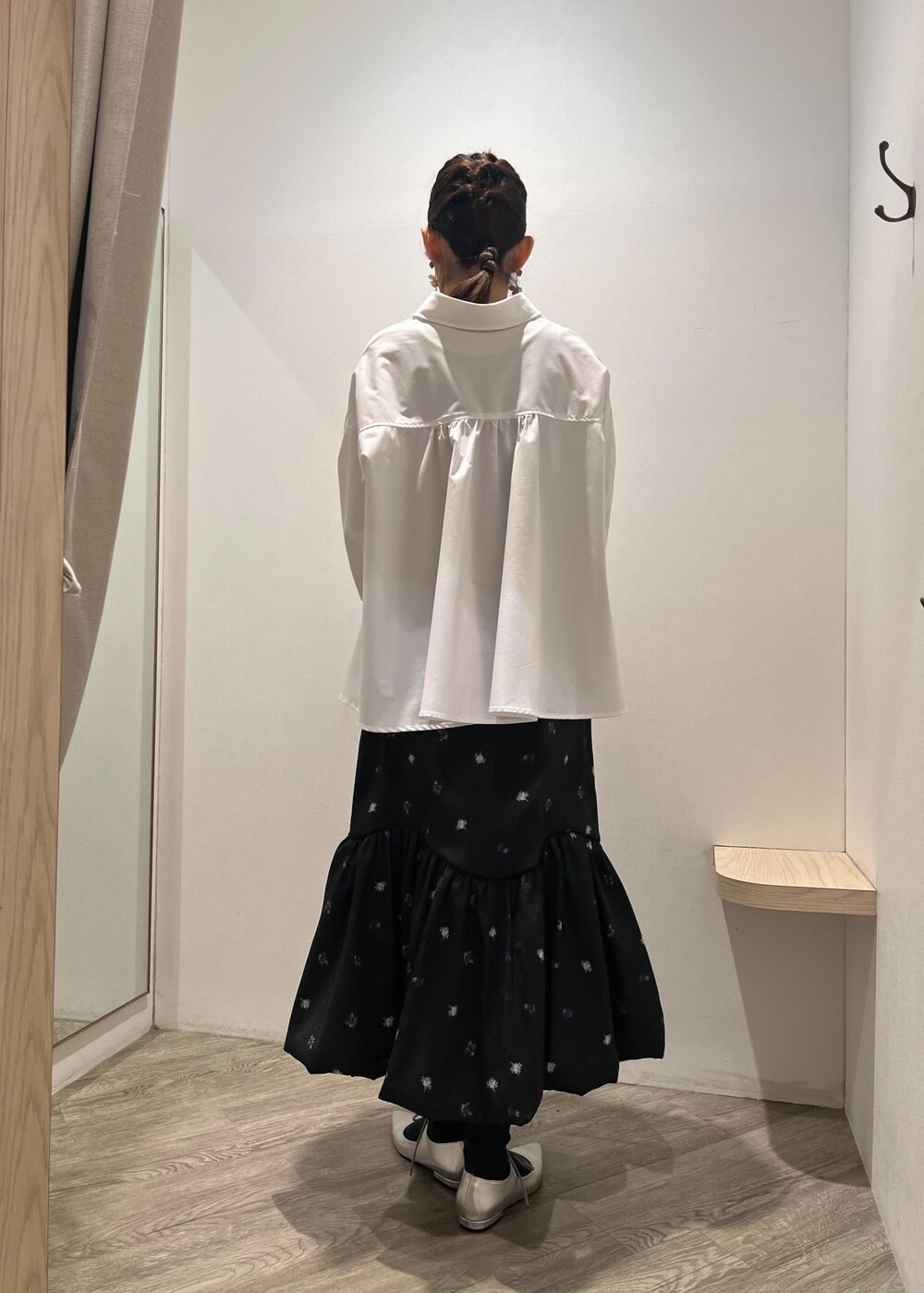 シルバー系のパンプス、イエロー系のショルダーバッグ、ブラック系のスカートを着用したレディースの冬コーディネートの3枚目の写真