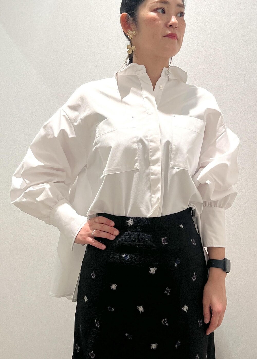 シルバー系のパンプス、イエロー系のショルダーバッグ、ブラック系のスカートを着用したレディースの冬コーディネートの4枚目の写真