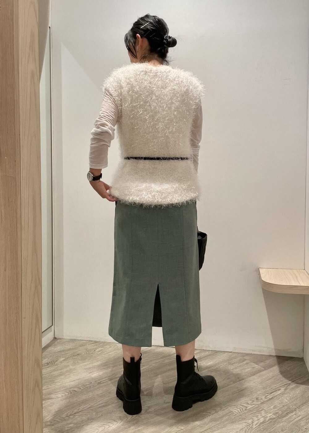 ホワイト系のベスト、グリーン系のスカート、ホワイト系のTシャツ/カットソーを着用したレディースの秋コーディネートの2枚目の写真