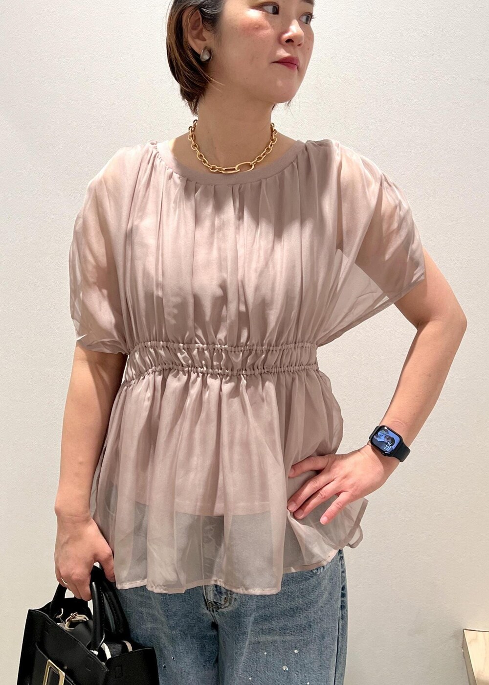 ブラック系のサンダル、ベージュ系のTシャツ/カットソー、ブルー系のデニムパンツを着用したレディースの春コーディネートの4枚目の写真