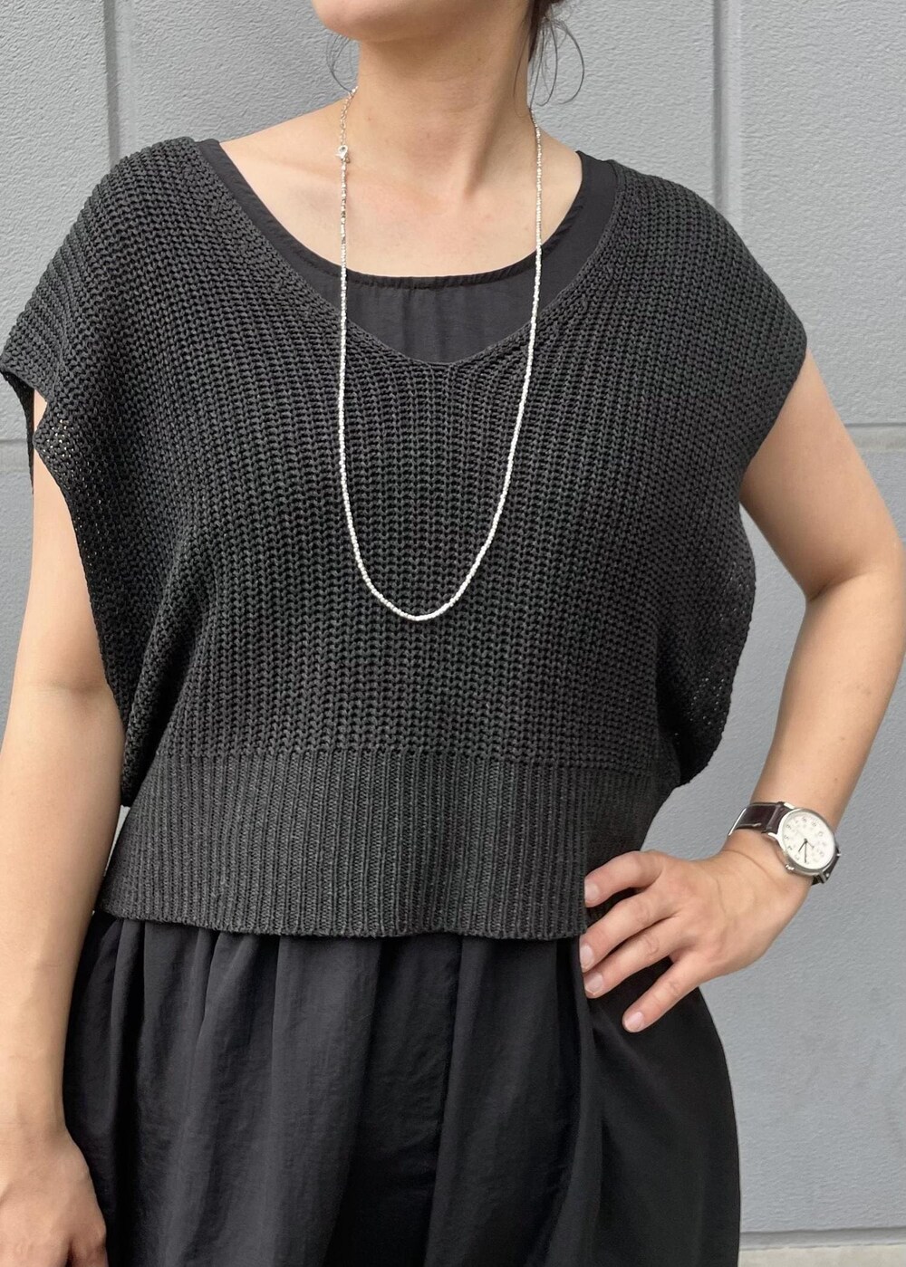 パープル系のショルダーバッグ、ブラック系のサンダル、ブラック系のワンピースを着用したレディースの夏コーディネートの3枚目の写真