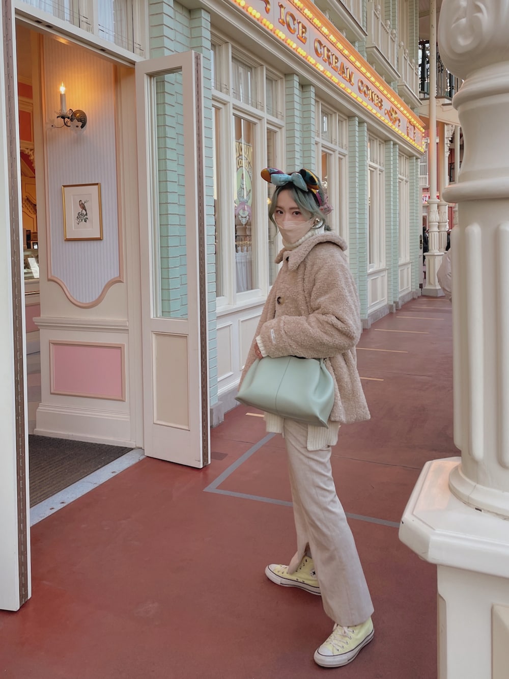 ベージュ系のジャケット/アウター、ホワイト系のニット/セーター、グリーン系のバッグを着用したレディースの冬コーディネートの2枚目の写真