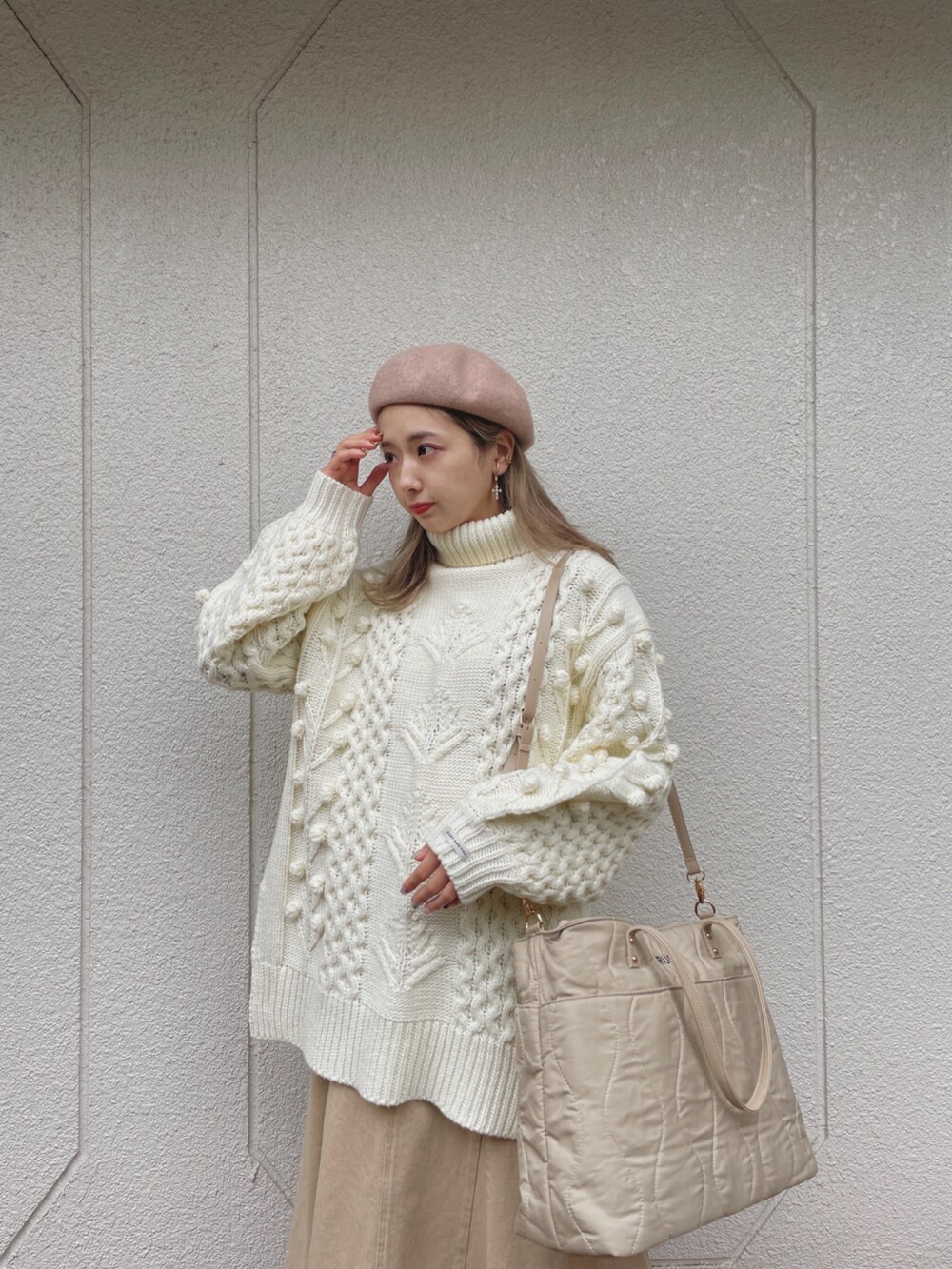 ホワイト系のニット/セーター、ベージュ系のバッグ、ベージュ系のスカートを着用したレディースの冬コーディネートの5枚目の写真